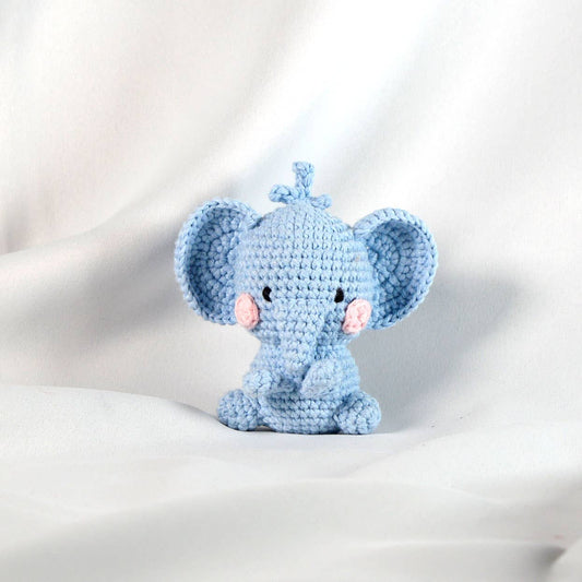 Crocheted blue elephant toy on a light gray background