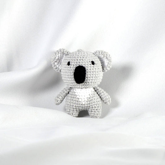 Crocheted grey koala toy on a white background